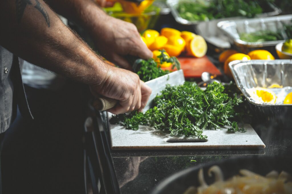 Chef chopping fresh herbs and vegetables